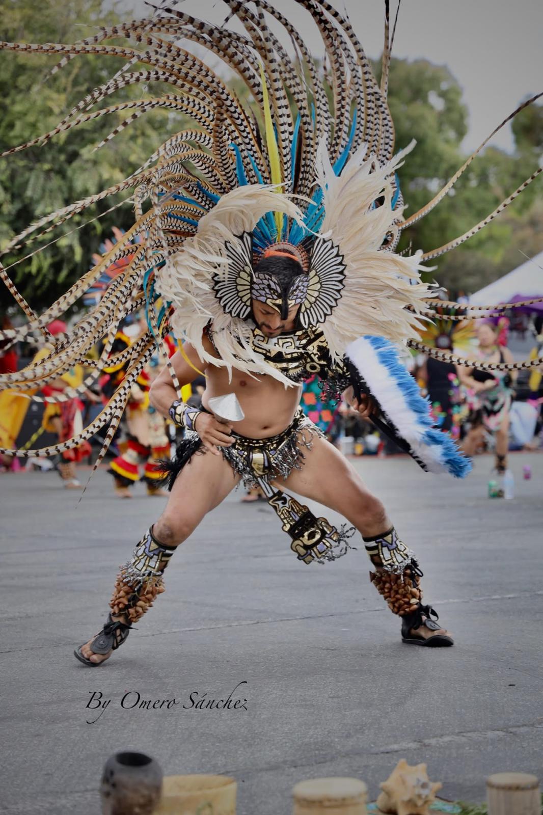 Aztec dancer in eagle headdress in wide stance mid-performance
